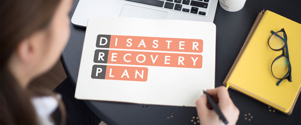 woman sitting at a desk looking at a disaster recover plan