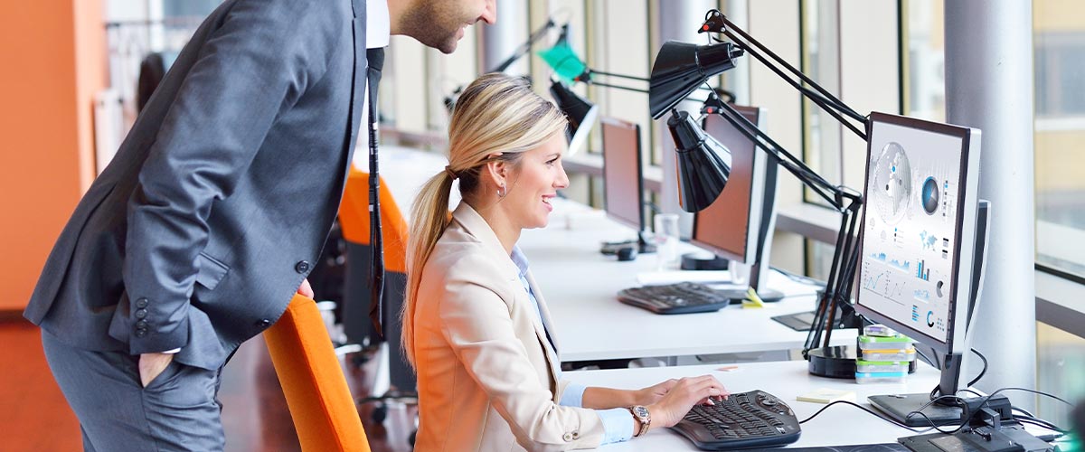 Happy employees looking at data on computer.